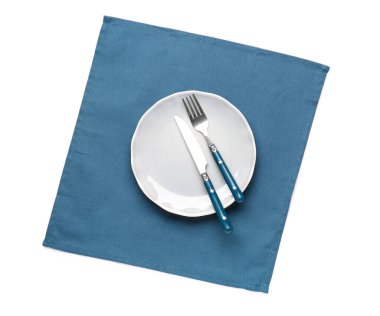 Çatal bıçak takımı ve temiz peçete beyaz arka planda izole edilmiş.