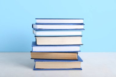 Masada mavi arkaplana karşı kitap yığını