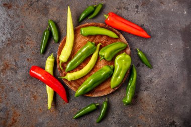 Koyu arka planda farklı taze biberli ahşap tahta.