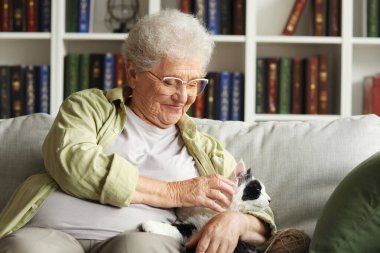 Evde dinlenen sevimli kedisi olan son sınıf öğrencisi kadın.