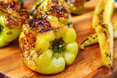 Farklı ızgara biberli ahşap tahta, yakın plan.