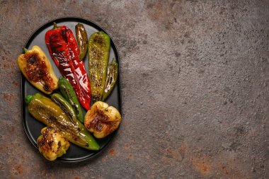Koyu arkaplanda farklı ızgara biberli tepsi
