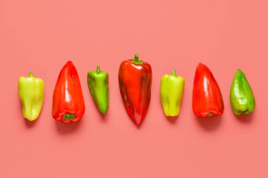 Kırmızı arka planda farklı taze dolmalık biber.