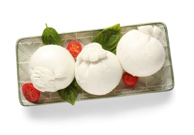 Beyaz arka planda fesleğenli ve domatesli bir tabak lezzetli Burrata peyniri.
