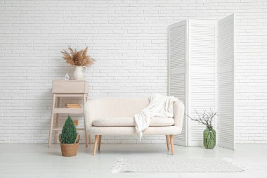 Beyaz kanepeli, raflı ve katlanabilir ekranlı şık bir oturma odası.