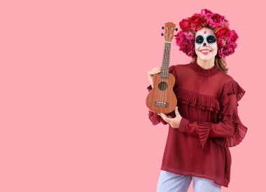 Pembe arka planda boyalı kafatası ve gitarı olan genç bir kadın. Meksika Ölüler Günü (El Dia de Muertos) kutlamaları