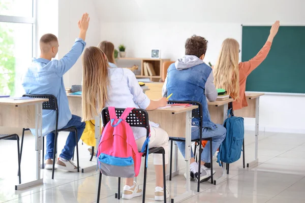クラスメイトが教室で答えるために手を上げる — ストック写真