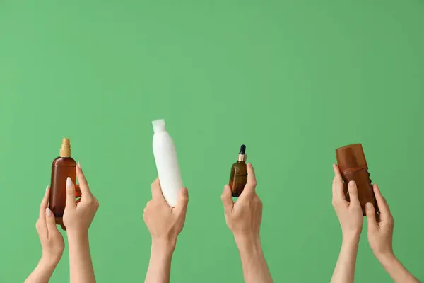 Weibliche Hände Mit Flaschen Sonnencreme Auf Grünem Hintergrund — Stockfoto