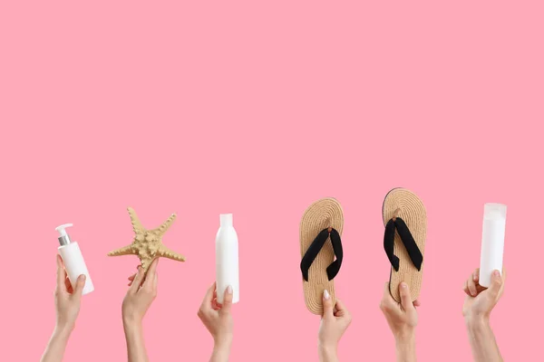 Руки Женщины Бутылками Крема Загара Шлепанцами Морскими Звездами Розовом Фоне — стоковое фото