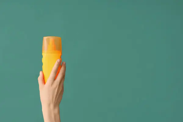 Weibliche Hand Mit Einer Flasche Sonnencreme Auf Grünem Hintergrund — Stockfoto