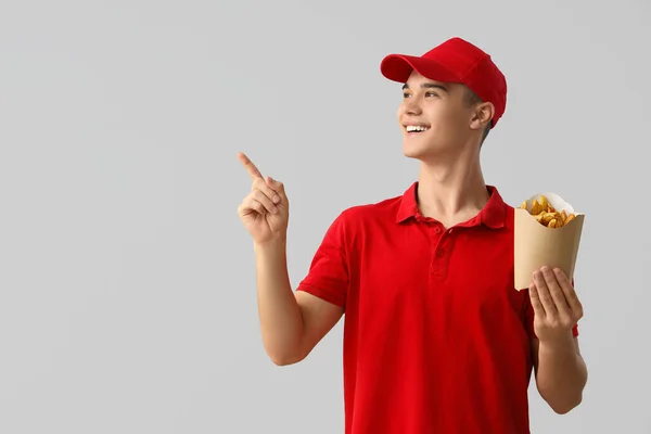 Ung Leverans Man Med Pommes Frites Pekar Något Ljus Bakgrund — Stockfoto