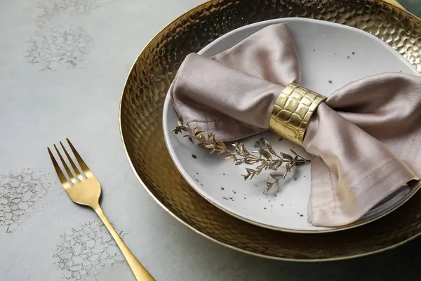 Elegant table setting with golden leaves and fork on grey table, closeup
