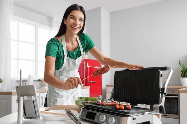 Young Woman Cooking Sausages Electric Grill Kitchen — Stock Photo, Image