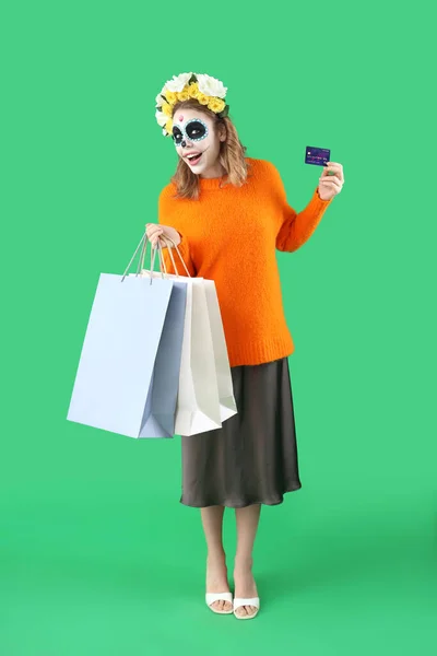 Junge Frau Mit Bemaltem Totenkopf Kreditkarte Und Einkaufstaschen Auf Grünem — Stockfoto