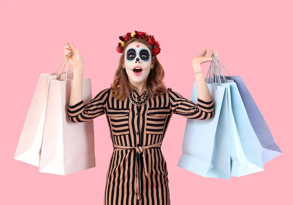 Überraschte Junge Frau Mit Bemaltem Totenkopf Und Einkaufstaschen Auf Rosa — Stockfoto