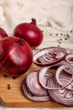 Beyaz ahşap zemin üzerinde taze soğan ve biber dilimleri olan tahta.