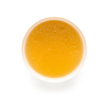 Beyaz arka planda bir kase lezzetli sebze suyu.