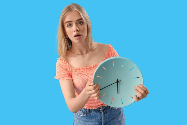 青い背景に時計を持ったストレスの若い女性 締め切りのコンセプト — ストック写真
