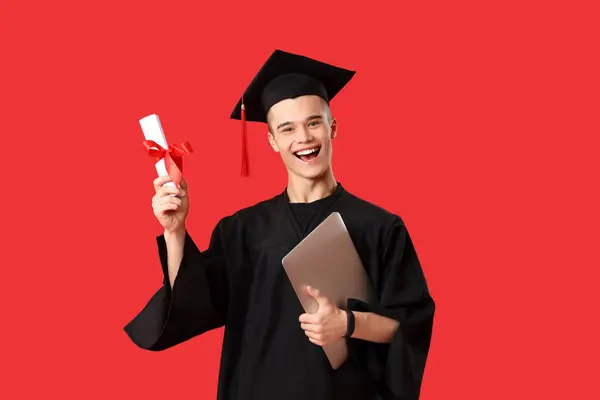 Mężczyzna Absolwent Student Dyplomem Laptop Czerwonym Tle — Zdjęcie stockowe