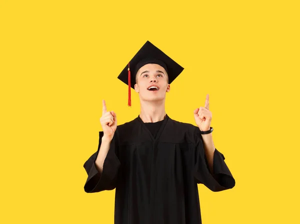 Mężczyzna Absolwent Student Wskazując Coś Żółtym Tle — Zdjęcie stockowe
