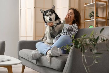 Evde köpekli mutlu genç bir kadın.