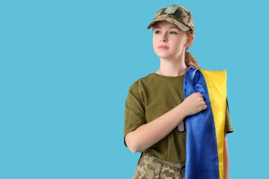 Açık mavi arka planda Ukrayna bayrağı taşıyan genç bayan asker