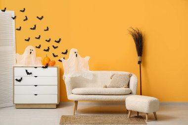 Cadılar Bayramı için dekore edilmiş oturma odasının içi kanepe ve çekmecelerle dolu.