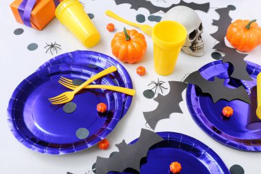 Beyaz arkaplanda Cadılar Bayramı süslemeleri olan şenlik masası