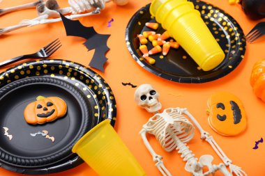 Turuncu arka planda Cadılar Bayramı süslemeleri olan şenlik masası