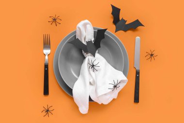 Cadılar Bayramı yarasaları ve turuncu arka planda örümcekleri olan şölen masası.