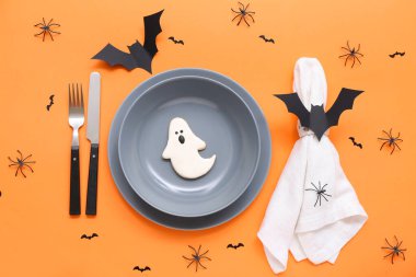 Cadılar Bayramı yarasaları, örümcekler ve turuncu arka planda hayaletler ile şenlik masası.