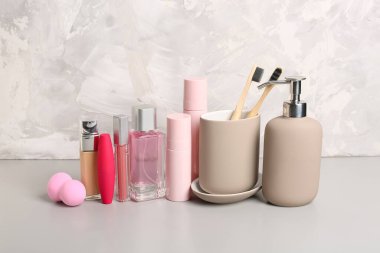 Grunge arka planında farklı kozmetik ürünleri, diş fırçaları ve makyaj süngeri