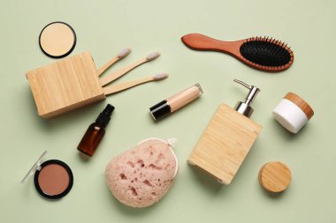 Farklı banyo malzemelerine ve yeşil arka planda kozmetik ürünlere sahip kompozisyon