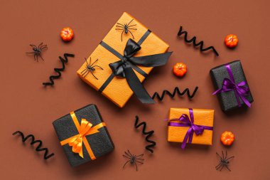 Renkli arkaplanda Cadılar Bayramı kutlaması için hediye kutuları ve dekor içeren kompozisyon