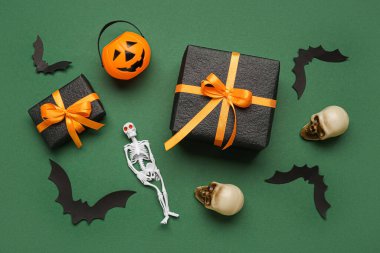 Yeşil arka planda hediyeli ve Cadılar Bayramı dekorasyonlu kompozisyon