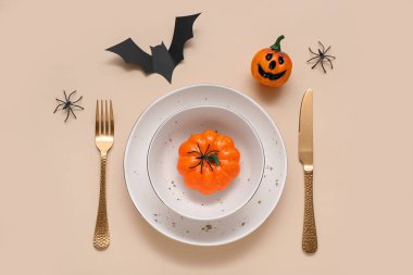 Cadılar Bayramı balkabakları ve bej arka planda yarasa ile şenlik masası