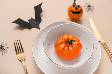 Cadılar Bayramı balkabakları ve bej arka planda yarasa ile şenlik masası