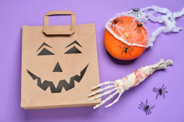 Alışveriş çantası ve leylak arka planda Cadılar Bayramı süslemeleri