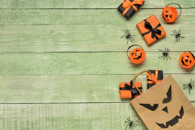 Alışveriş çantalı kompozisyon, hediyeler ve renkli ahşap arka planda Cadılar Bayramı süslemeleri