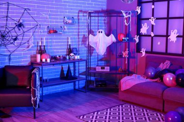 Cadılar Bayramı dekorlu ve raf üniteli karanlık oturma odasının içi.