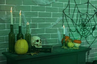 Balkabağıyla mum yakmak ve karanlık odada masanın üstünde Cadılar Bayramı dekoru