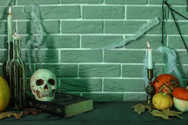 Karanlık odada şömine rafında mum, balkabağı ve kafatası yakmak.