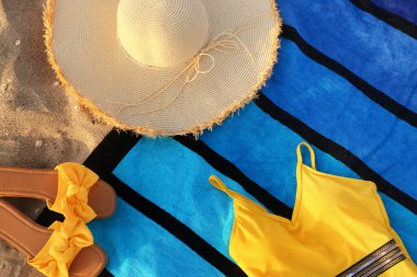Kum üzerinde şık plaj aksesuarları olan kompozisyon