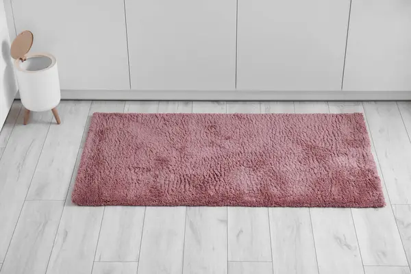 Soft rug and trash bin on floor in kitchen