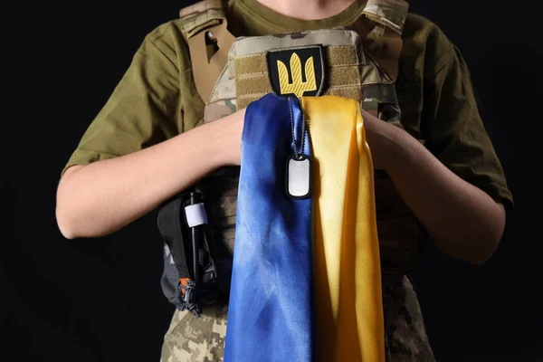 ウクライナの旗を持つ若い女性兵士と暗い背景に軍事タグ — ストック写真