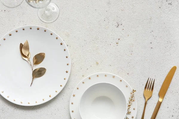 Elegant table setting with golden leaves and cutlery on white table