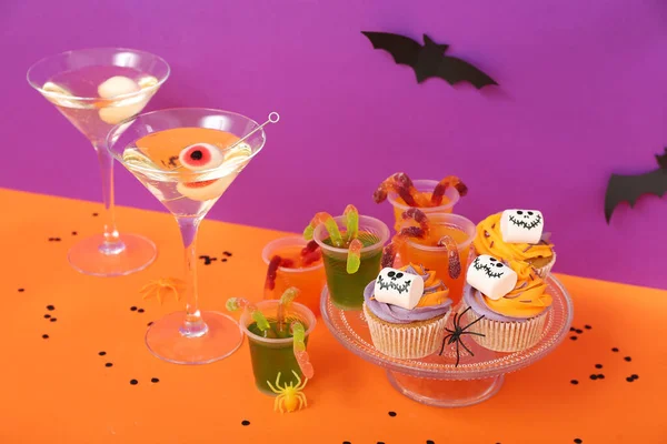 보라색 배경에 오렌지 테이블에 케이크 마티니와 할로윈 — 스톡 사진