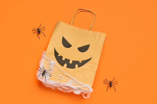 Composition with shopping bag and Halloween decorations on color background