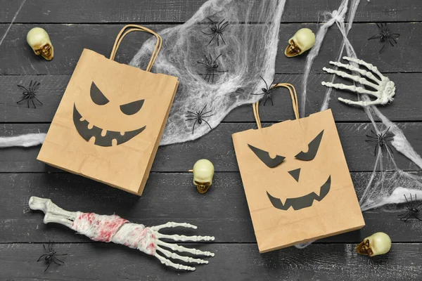 Composition with shopping bags and Halloween decorations on dark wooden background