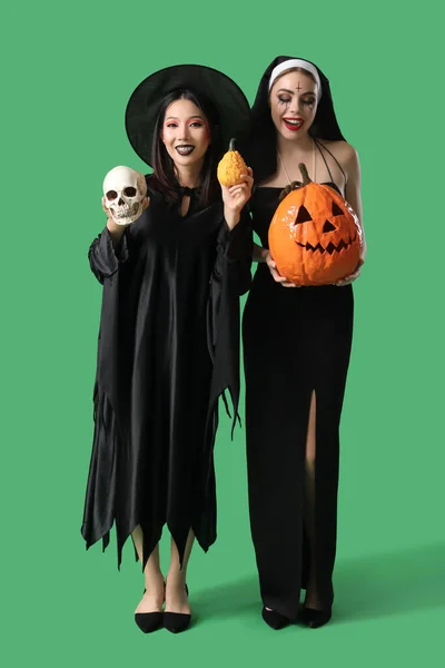 Female Friends Costumes Halloween Party Pumpkins Green Background — Stock Photo, Image